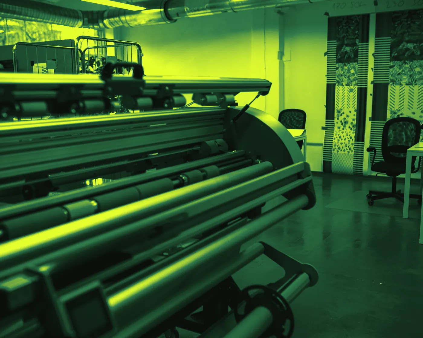 Un operario trabaja junto a un plotter de gran formato en el taller de una gráfica